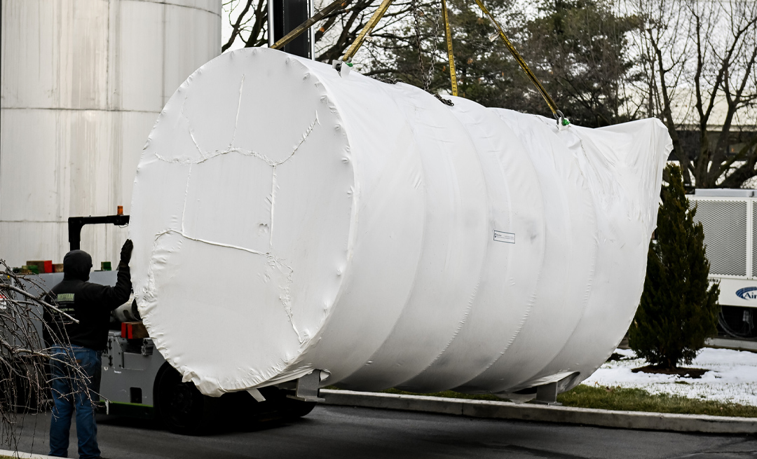 a large cylinder container being moved by a lift
