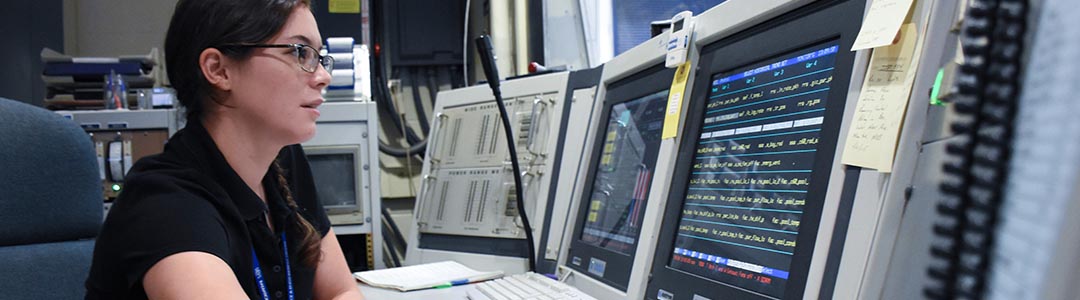 a woman in work at the reactor control panel